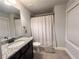 Well-lit bathroom with granite countertops, a single vanity, and a shower at 552 Warrenton Run Dr, Sugar Hill, GA 30518