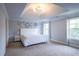 Spacious bedroom featuring plush carpet, decorative chandelier, and bright windows at 552 Warrenton Run Dr, Sugar Hill, GA 30518