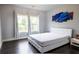 Bright bedroom features hardwood floors, natural light from the windows, and a plush white bed at 552 Warrenton Run Dr, Sugar Hill, GA 30518