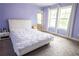 Lilac bedroom with white furniture, carpet flooring and natural lighting at 552 Warrenton Run Dr, Sugar Hill, GA 30518