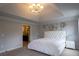 Spacious bedroom featuring plush carpet, decorative chandelier, and bright windows at 552 Warrenton Run Dr, Sugar Hill, GA 30518