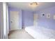 View of the lilac bedroom with decorative chandelier, white trim, and carpet flooring at 552 Warrenton Run Dr, Sugar Hill, GA 30518