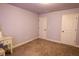 Bedroom with neutral carpet, simple trim and paint, and multiple doors at 552 Warrenton Run Dr, Sugar Hill, GA 30518