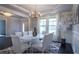 Bright dining area with chandelier, white table, wainscoting, and windows, perfect for Gathering meals and gatherings at 552 Warrenton Run Dr, Sugar Hill, GA 30518