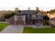 Beautiful two-story home featuring a well-manicured lawn, stone accents, and a two-car garage at 552 Warrenton Run Dr, Sugar Hill, GA 30518