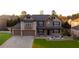 Stunning two-story brick home with a well-manicured lawn and three-car garage at 552 Warrenton Run Dr, Sugar Hill, GA 30518