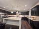 Kitchen area with stainless steel appliances, dark cabinets and large center island at 552 Warrenton Run Dr, Sugar Hill, GA 30518