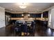 This spacious kitchen features dark wood cabinets, a center island, stainless appliances and a dining area at 552 Warrenton Run Dr, Sugar Hill, GA 30518