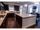 Stylish kitchen with stainless steel appliances, dark wood cabinets, granite counters, and a kitchen island at 552 Warrenton Run Dr, Sugar Hill, GA 30518