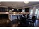 Spacious kitchen with dark cabinets, granite counters, an island, and a breakfast table with seating at 552 Warrenton Run Dr, Sugar Hill, GA 30518