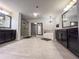 Expansive main bathroom with dual vanities, soaking tub, glass enclosed shower, and elegant light fixtures at 552 Warrenton Run Dr, Sugar Hill, GA 30518