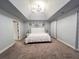 Light-filled main bedroom featuring modern lighting, carpeted floors and neutral décor at 552 Warrenton Run Dr, Sugar Hill, GA 30518