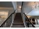 View of the carpeted staircase with dark wooden handrail and decorative chandelier at 552 Warrenton Run Dr, Sugar Hill, GA 30518
