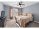 Bedroom featuring a ceiling fan, window with natural light, grey walls, and a bed with neutral-colored bedding at 1035 Bridle Path Dr, Lawrenceville, GA 30045