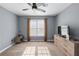 Bedroom featuring a ceiling fan, natural light from a window, and neutral-colored walls complemented by carpeted flooring at 1035 Bridle Path Dr, Lawrenceville, GA 30045