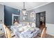 Formal dining room featuring a chandelier, table set for six, and adjacent rooms at 1035 Bridle Path Dr, Lawrenceville, GA 30045