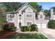 Charming stucco two-story home with a well-manicured lawn and two-car garage at 1035 Bridle Path Dr, Lawrenceville, GA 30045