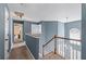 Upstairs hallway with carpet, wood railing staircase, arched window, and natural light at 1035 Bridle Path Dr, Lawrenceville, GA 30045