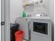 Functional laundry room with a front-loading washer and dryer; the space includes shelving for storage and cleaning supplies at 1035 Bridle Path Dr, Lawrenceville, GA 30045
