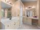 Main bathroom showcasing double vanity sinks, bathtub, glass door shower, and vanity with seating area at 1035 Bridle Path Dr, Lawrenceville, GA 30045
