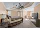 Spacious main bedroom with tray ceiling, ceiling fan, carpet floors, sitting area, and multiple windows at 1035 Bridle Path Dr, Lawrenceville, GA 30045