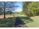 Tranquil walking path along a grassy lawn, connecting to a picturesque lakeside view at 1035 Bridle Path Dr, Lawrenceville, GA 30045