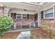 Charming brick home with a decorative porch, iron railings, and mature landscaping at 1868 Fort Valley Sw Dr, Atlanta, GA 30311