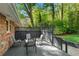 Outdoor living on the wooden back deck with fence, chairs, and lush green trees surrounding at 2799 Briarglen Dr, Atlanta, GA 30340