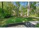 Enjoy the serene backyard with well-maintained lawn, mature trees, and wooden retaining wall at 2799 Briarglen Dr, Atlanta, GA 30340