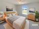 Bright bedroom with a big window, a wooden frame bed, neutral tones, and modern decor at 55 Ratliff Dr, Covington, GA 30016