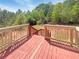 Wooden deck with painted stairs and railing, overlooking a wooded backyard on a sunny day at 55 Ratliff Dr, Covington, GA 30016