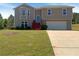Charming two-story home featuring a bay window, red steps, and an attached two-car garage at 55 Ratliff Dr, Covington, GA 30016
