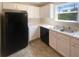 Well-lit kitchen with stainless steel sink, dark appliances, and white cabinets at 55 Ratliff Dr, Covington, GA 30016