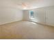 Open living room features a ceiling fan, plush carpeting, and natural light from a window at 55 Ratliff Dr, Covington, GA 30016