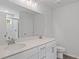 Modern bathroom featuring double sinks, white cabinets, and a marble tiled shower with glass door at 6108 Marigold Way, Atlanta, GA 30349