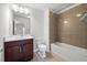 Bright bathroom featuring a vanity with a dark wood cabinet and a shower over tub with beige tiling at 667 Creswell Park, Smyrna, GA 30082
