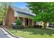 Charming brick home featuring a manicured lawn and inviting front porch with white columns at 1817 Bedfordshire Dr, Decatur, GA 30033