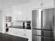 Bright kitchen featuring stainless steel refrigerator, granite countertops and white cabinets at 1817 Bedfordshire Dr, Decatur, GA 30033