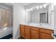 Bathroom boasts double sinks with vanity, a large mirror, and a shower/tub with white tile at 235 South St, Buford, GA 30518