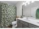 Well-lit bathroom with a floral shower curtain, modern sink and a gray cabinet at 235 South St, Buford, GA 30518