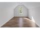 Large bonus room featuring a window, wood-look flooring, and white trim at 235 South St, Buford, GA 30518