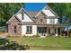 Charming two-story home featuring stone accents, white siding, and a welcoming front porch with craftsman-style details at 235 South St, Buford, GA 30518