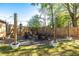 Backyard fire pit area with chairs, ambient lighting, and lush landscaping at 235 South St, Buford, GA 30518