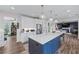Bright kitchen with a blue island with seating, stainless steel refrigerator, and open layout at 235 South St, Buford, GA 30518