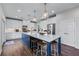 Spacious kitchen featuring a large island with seating, white cabinetry, stainless appliances and hardwood floors at 235 South St, Buford, GA 30518