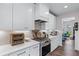 Modern kitchen featuring white cabinetry, stainless steel appliances, and a stylish backsplash at 235 South St, Buford, GA 30518