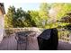 Back deck featuring a grill and an outdoor dining set surrounded by lush trees at 2553 Twilight Vw, Snellville, GA 30078