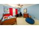 Bedroom with blue walls, window, red curtains, beige carpet, and wooden furniture at 2553 Twilight Vw, Snellville, GA 30078