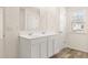 Bathroom featuring double sink vanity with tile floors and ample lighting at 310 Silver Moon Drive # 111, Loganville, GA 30052