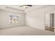Large bedroom with plush carpeting, tray ceiling, fan, and a view of neighboring houses at 310 Silver Moon Drive # 111, Loganville, GA 30052